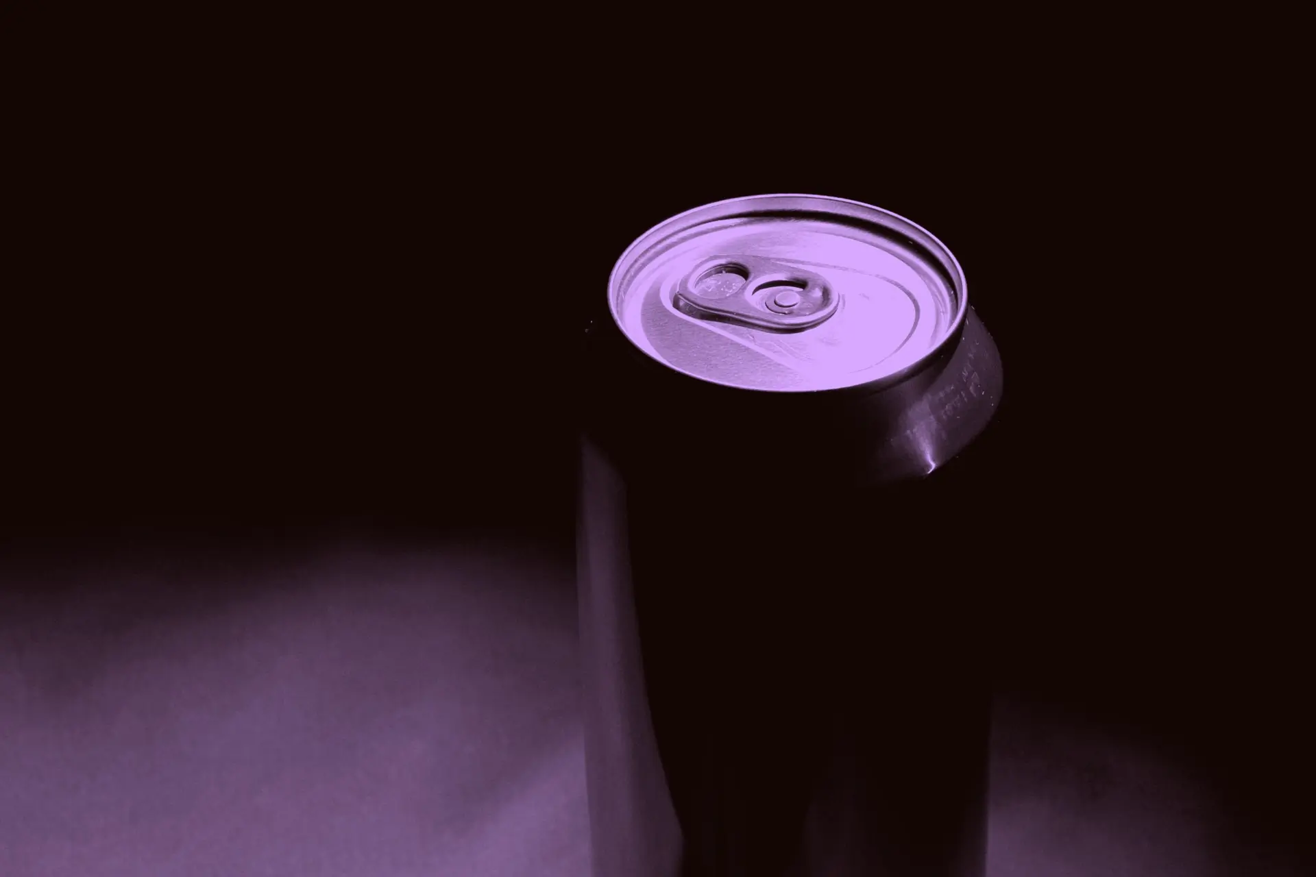 An unopened can emerging from darkness, graded in the grape lilac