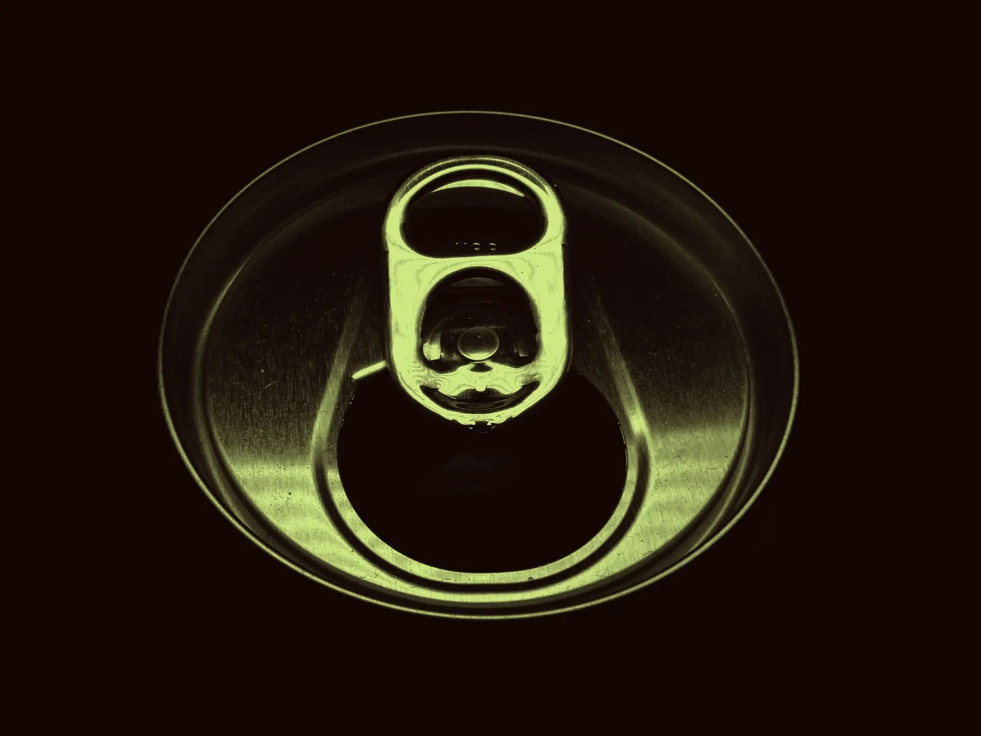 An opened can top shot close against black, graded in the bitter lemon green