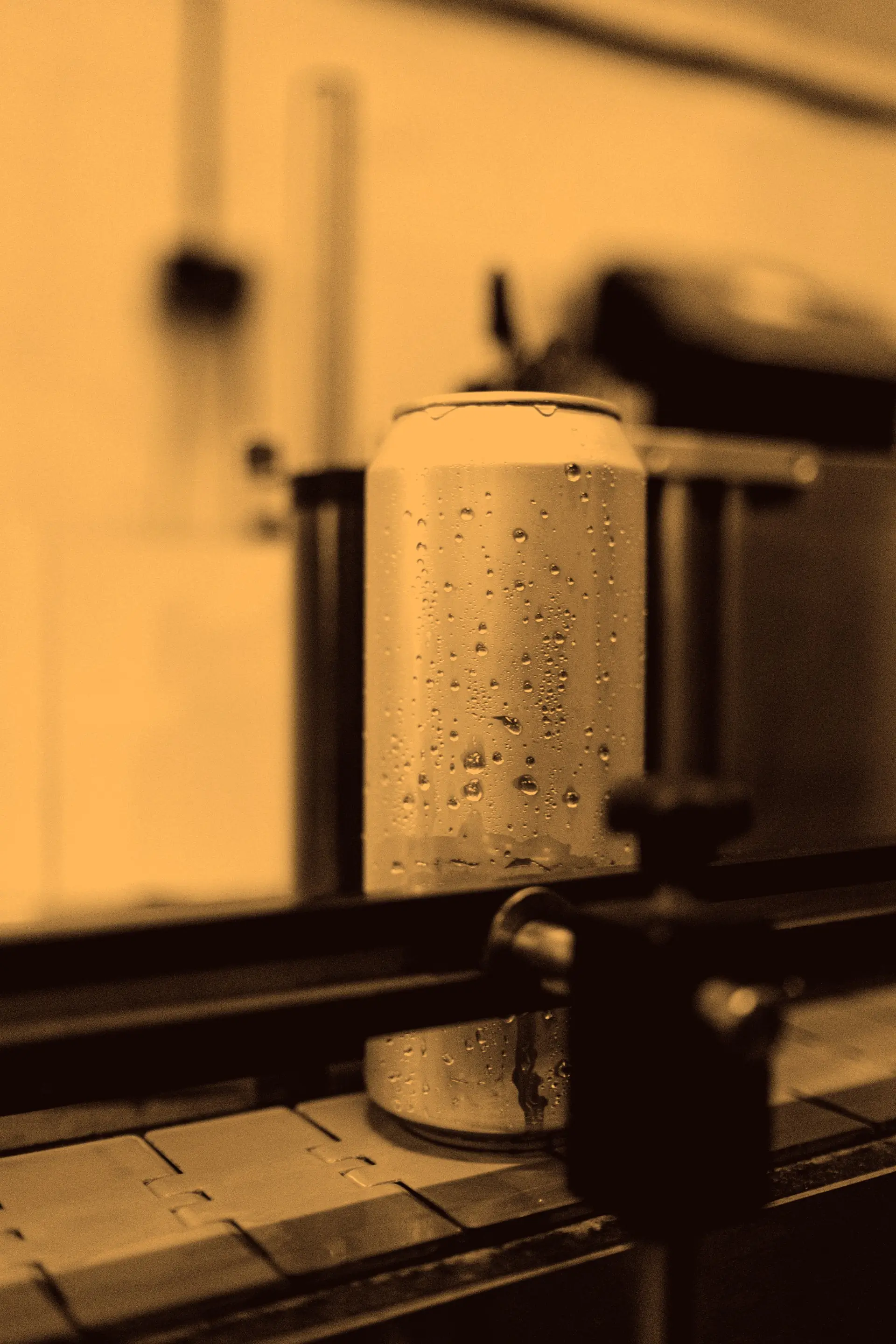 A dew covered can on the line, graded in the orange flavour amber