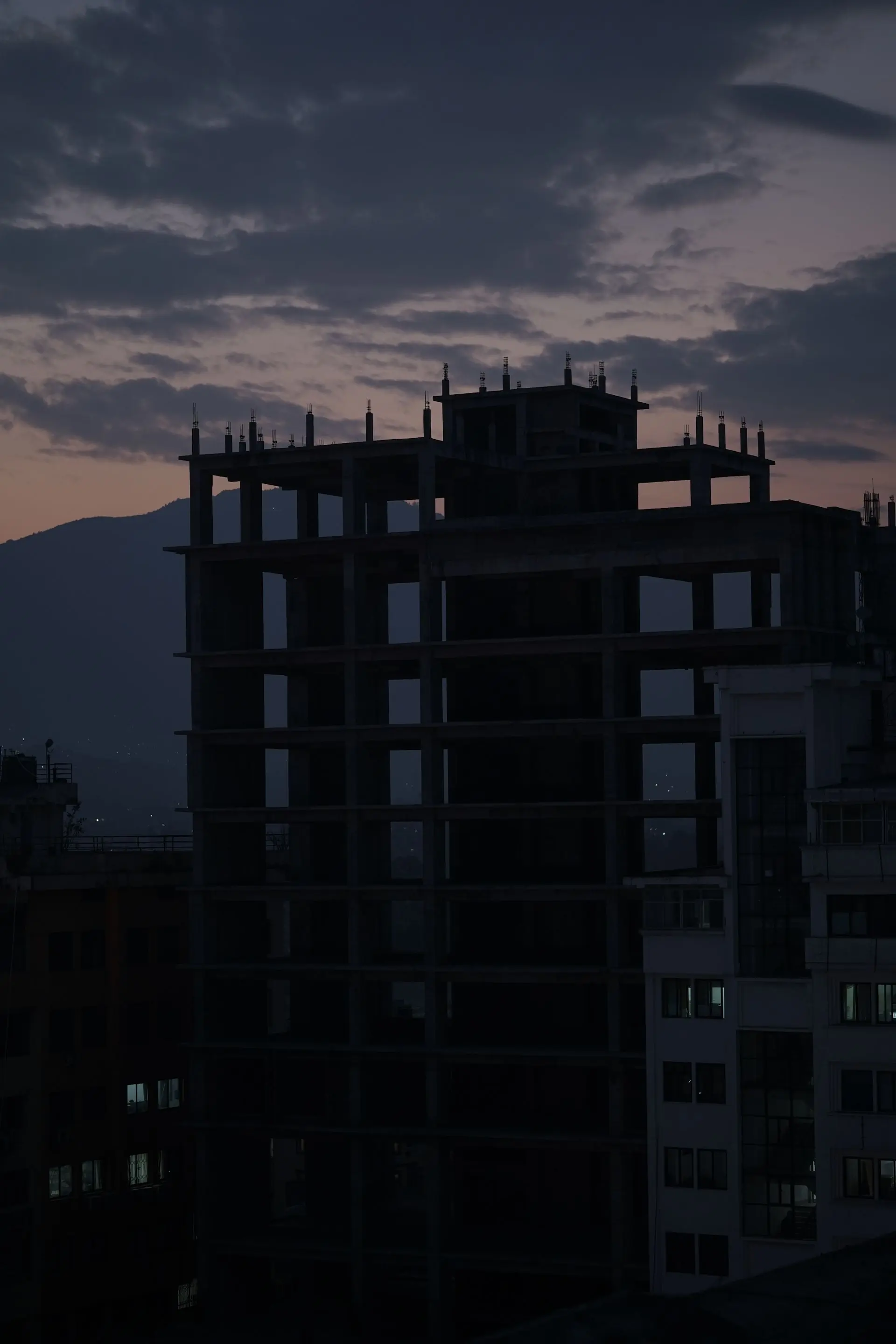 A concrete frame topped out against the dusk