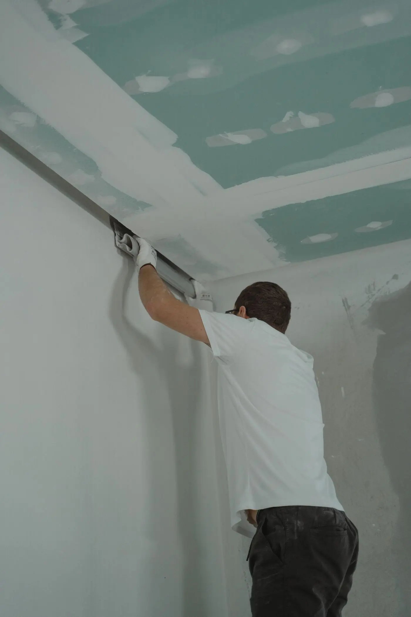 A finisher working overhead on an occupied fit-out