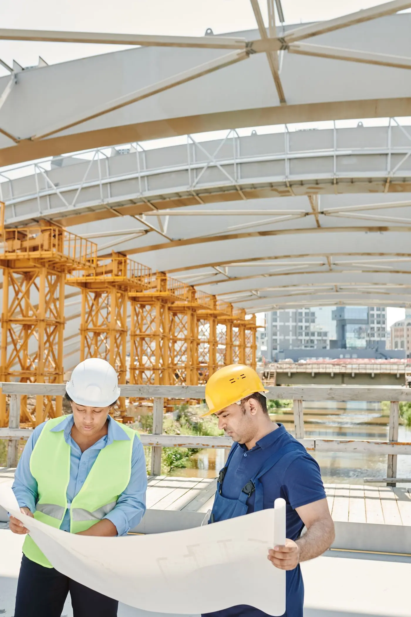 Two engineers reading a drawing under a timber falsework deck