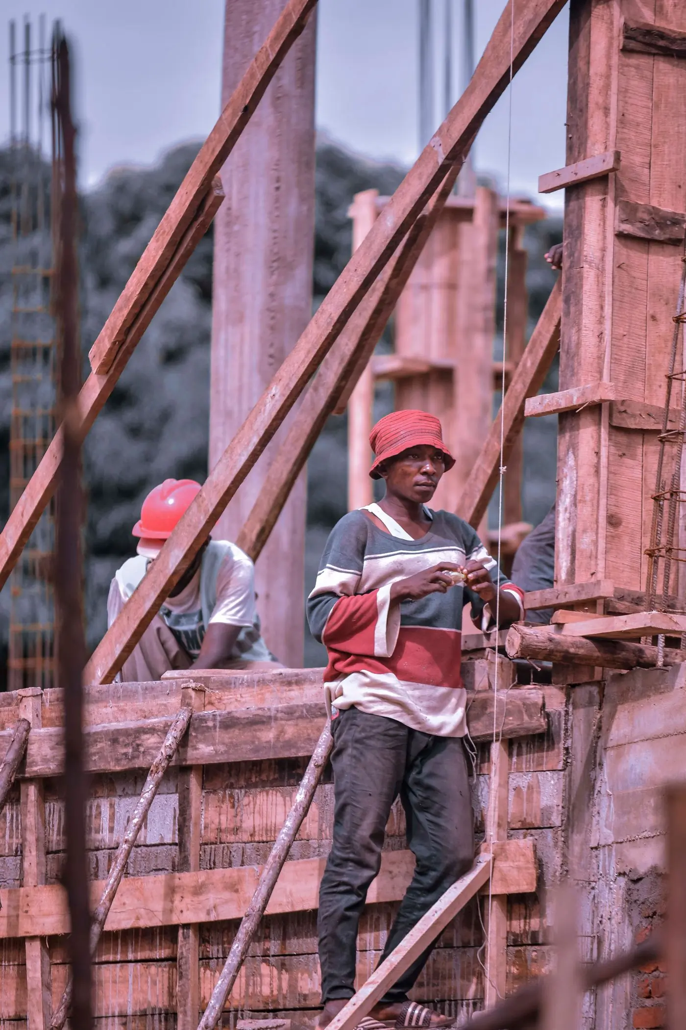 Fitters working from timber scaffolding on an early job