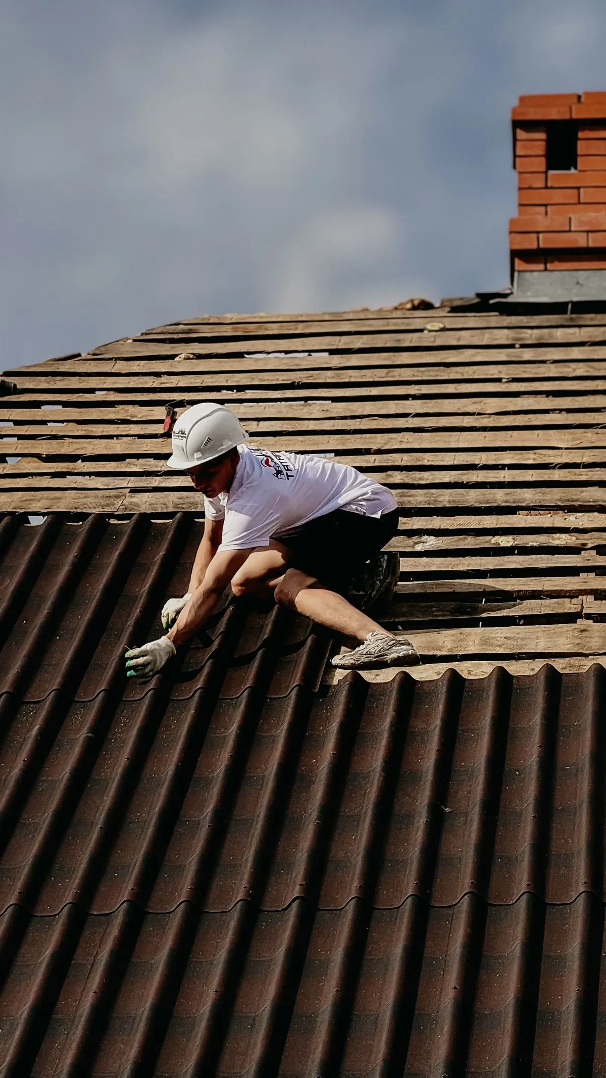 A fitter setting a tile on a steep pitch