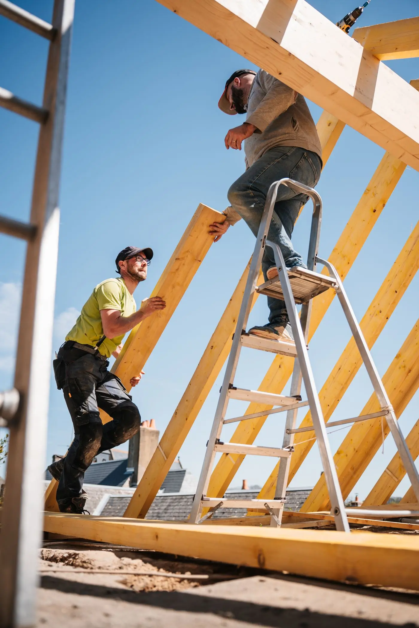 Two carpenters setting the rafters of a new roof