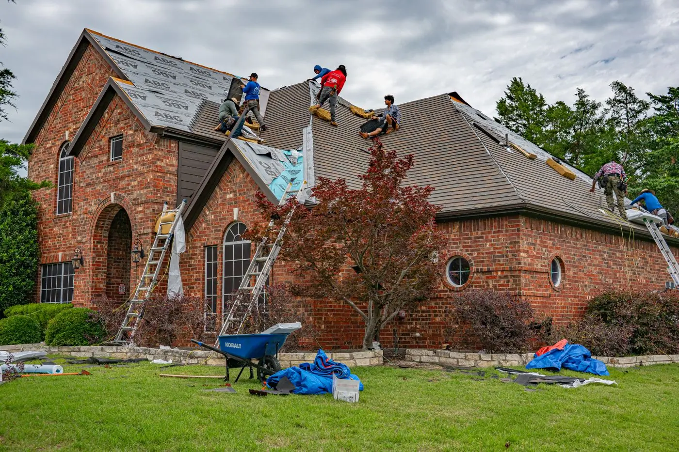 A four-man crew stripping and re-covering a house roof