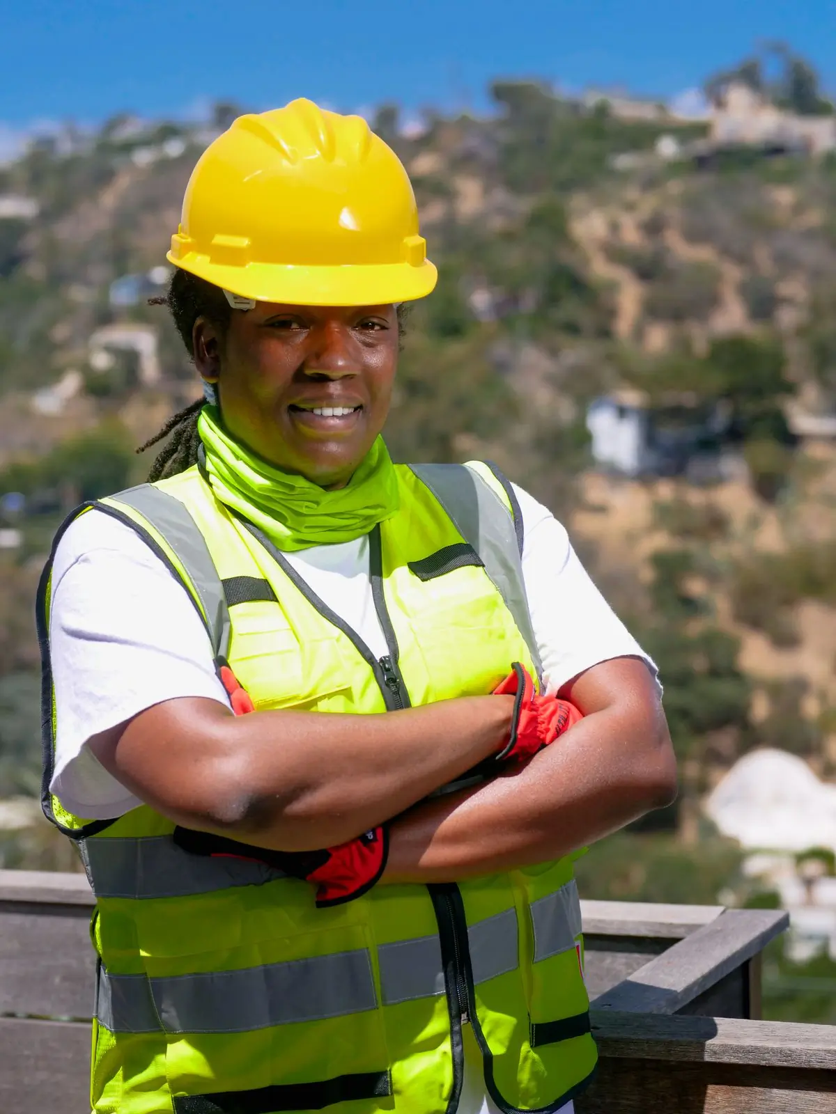 A site supervisor in a hard hat above a hillside of finished roofs
