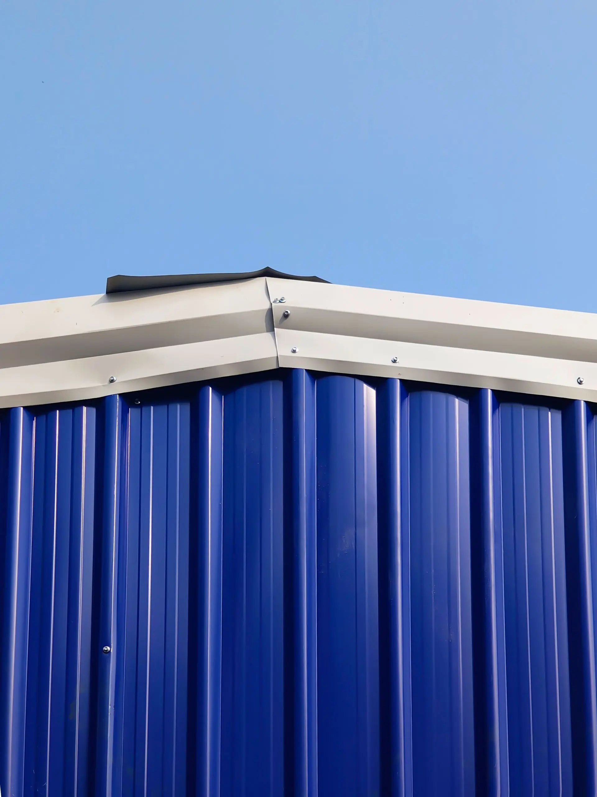 The edge detail of a blue standing-seam metal roof