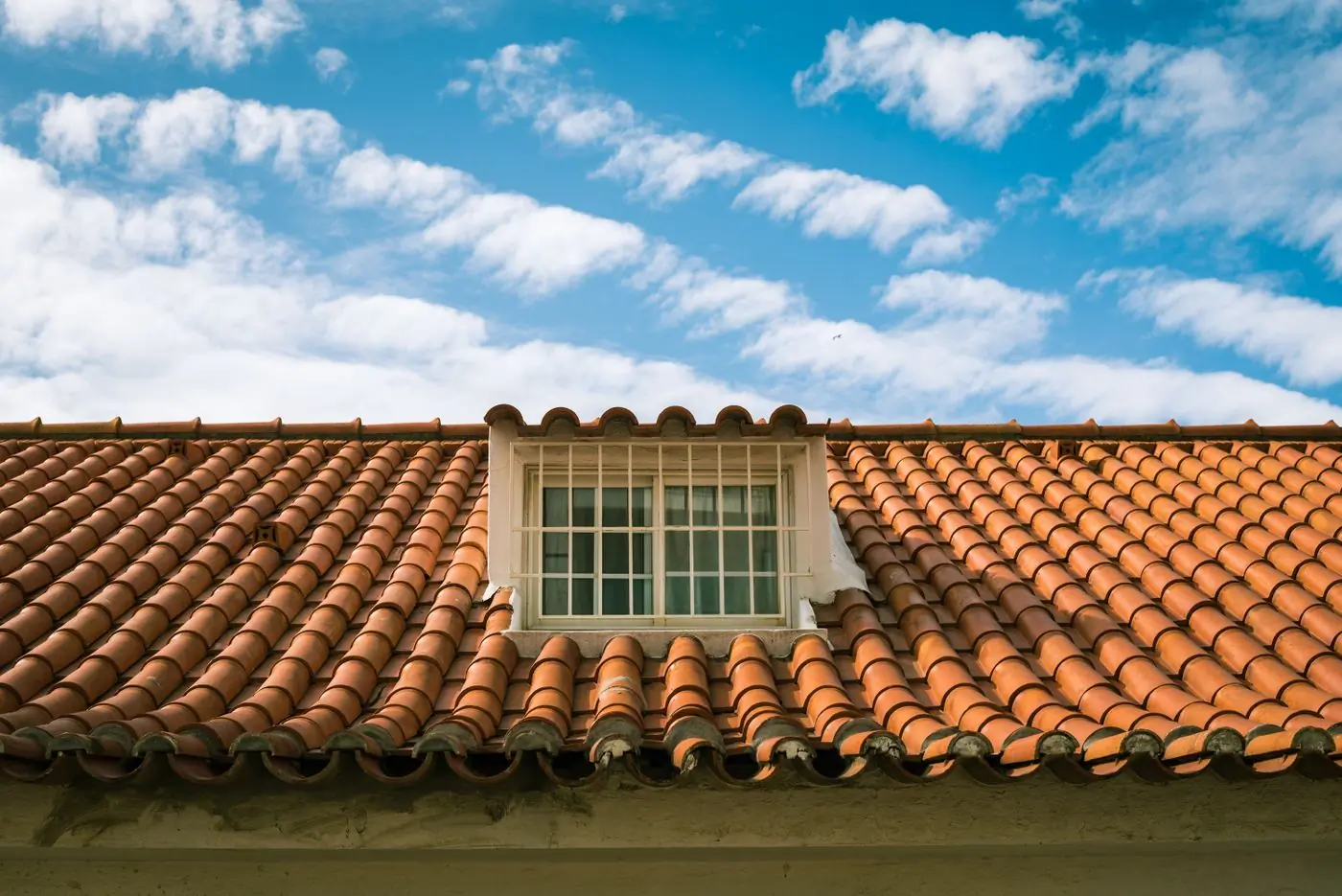 A terracotta tiled roof with a skylight set into the slope