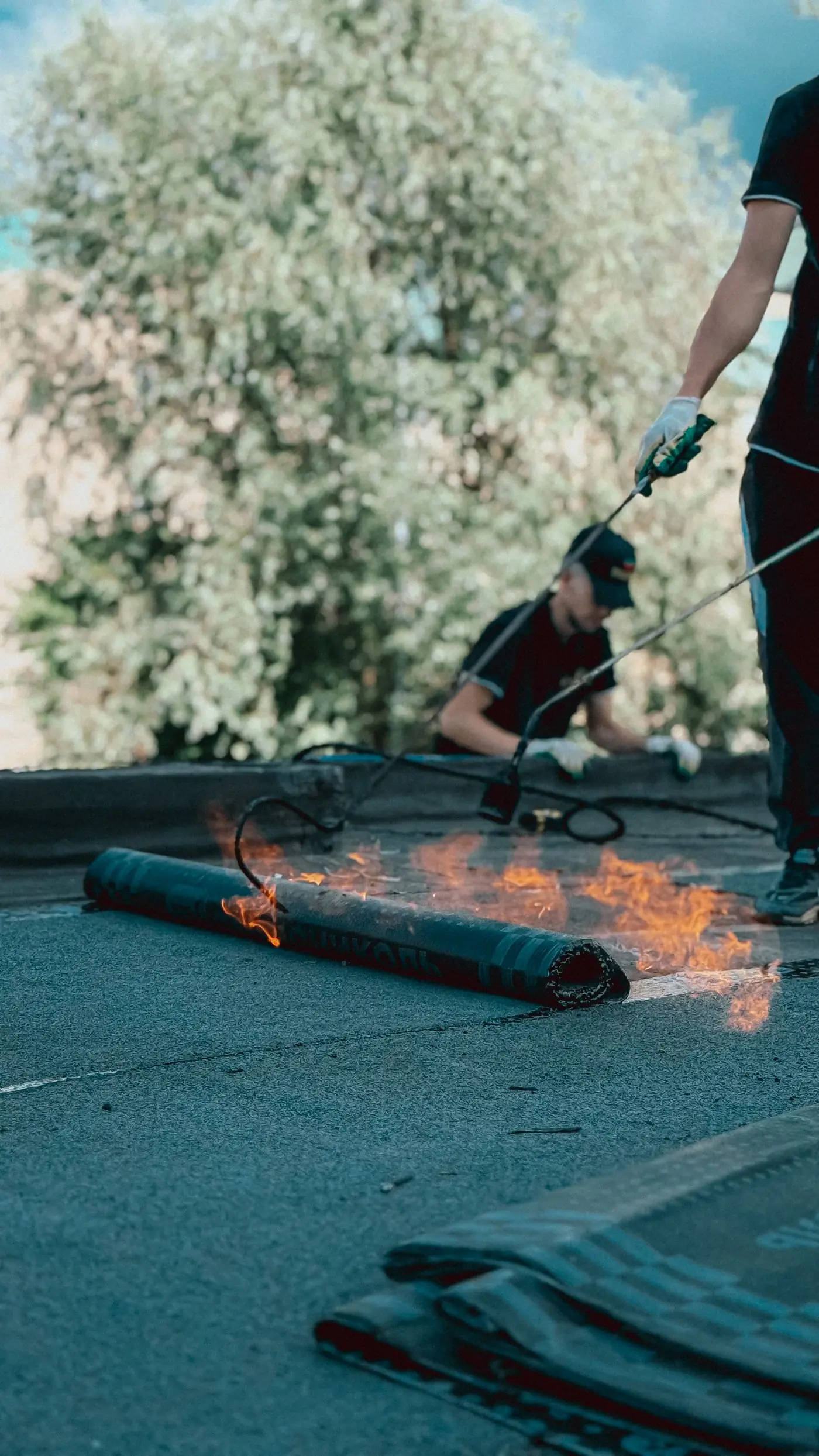 A torch-on membrane being bonded to a flat roof deck