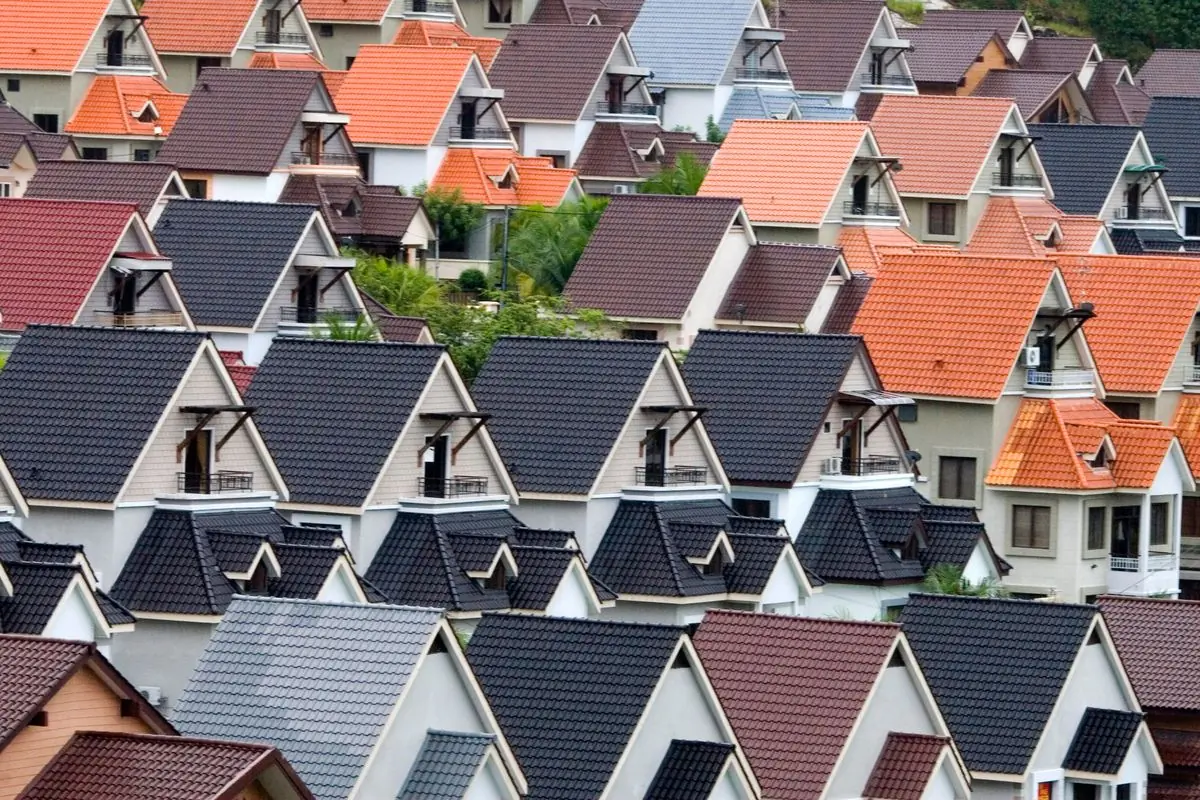 Rows of suburban rooftops in mixed colours seen from above