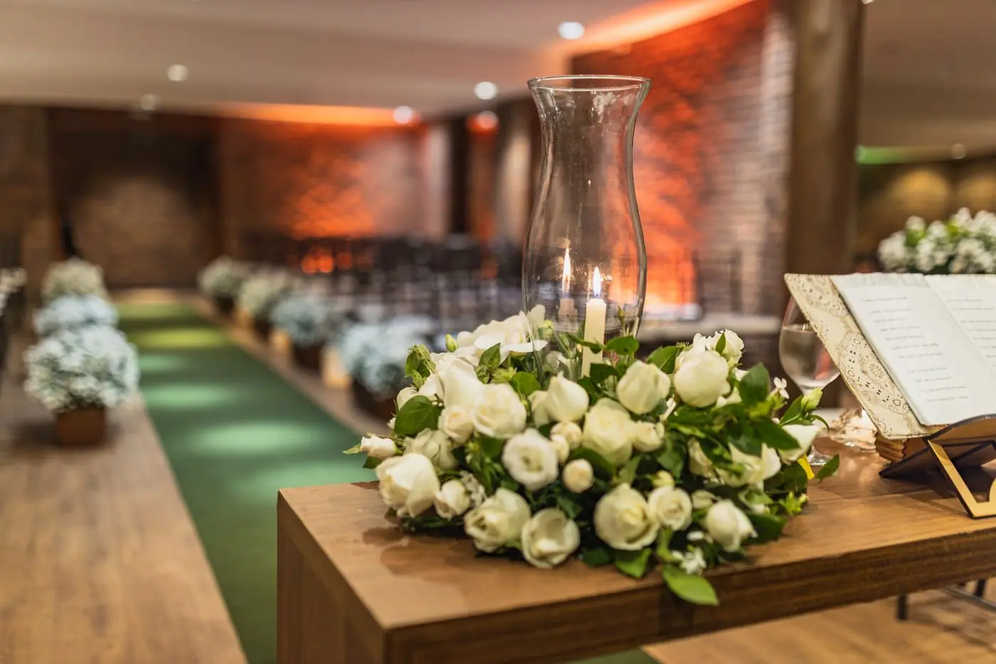 A white rose arrangement standing in a softly lit venue