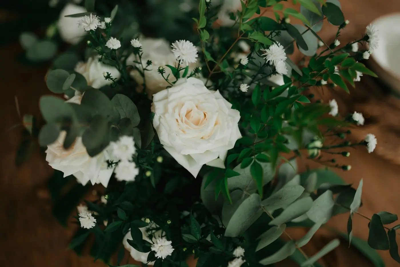 A close arrangement of white roses and eucalyptus