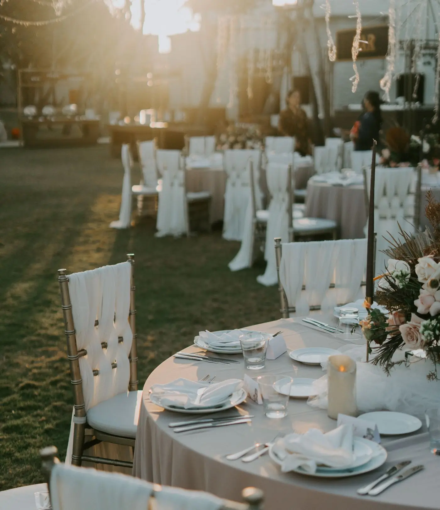 Tables and chairs set for an outdoor reception under trees
