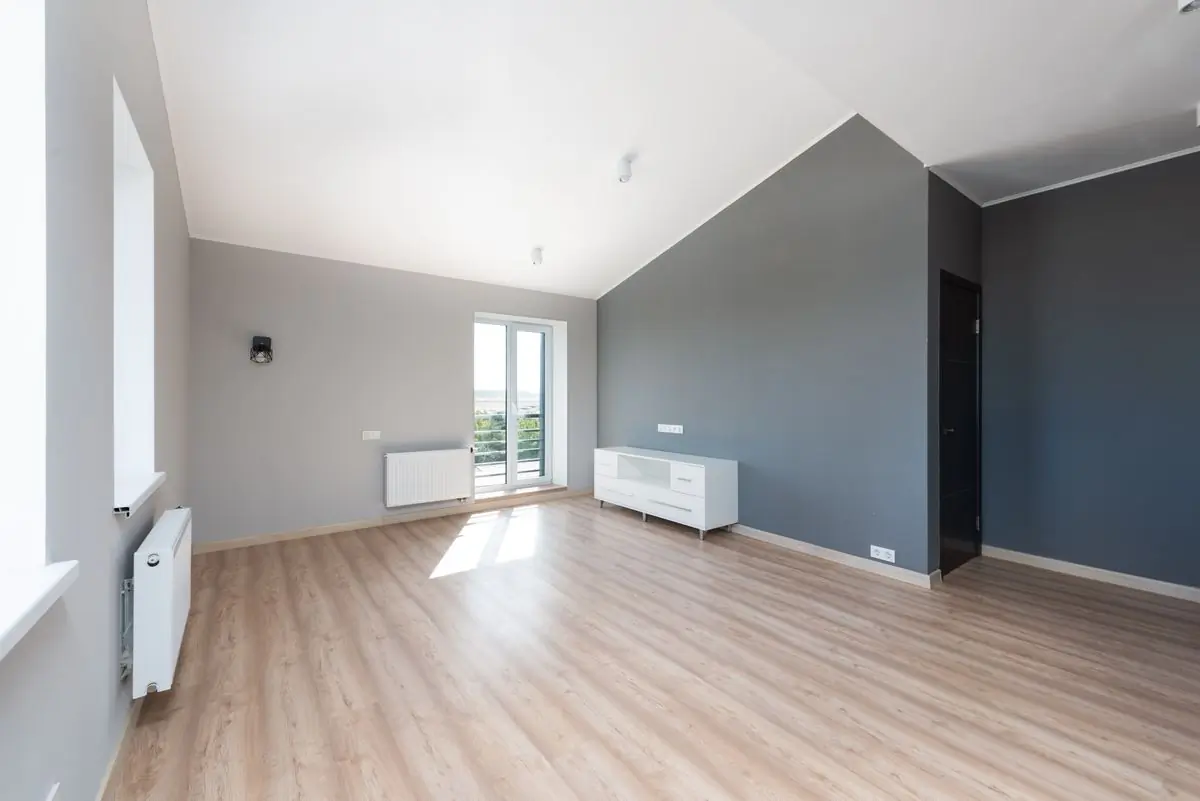 An empty finished apartment with two grey walls and new flooring
