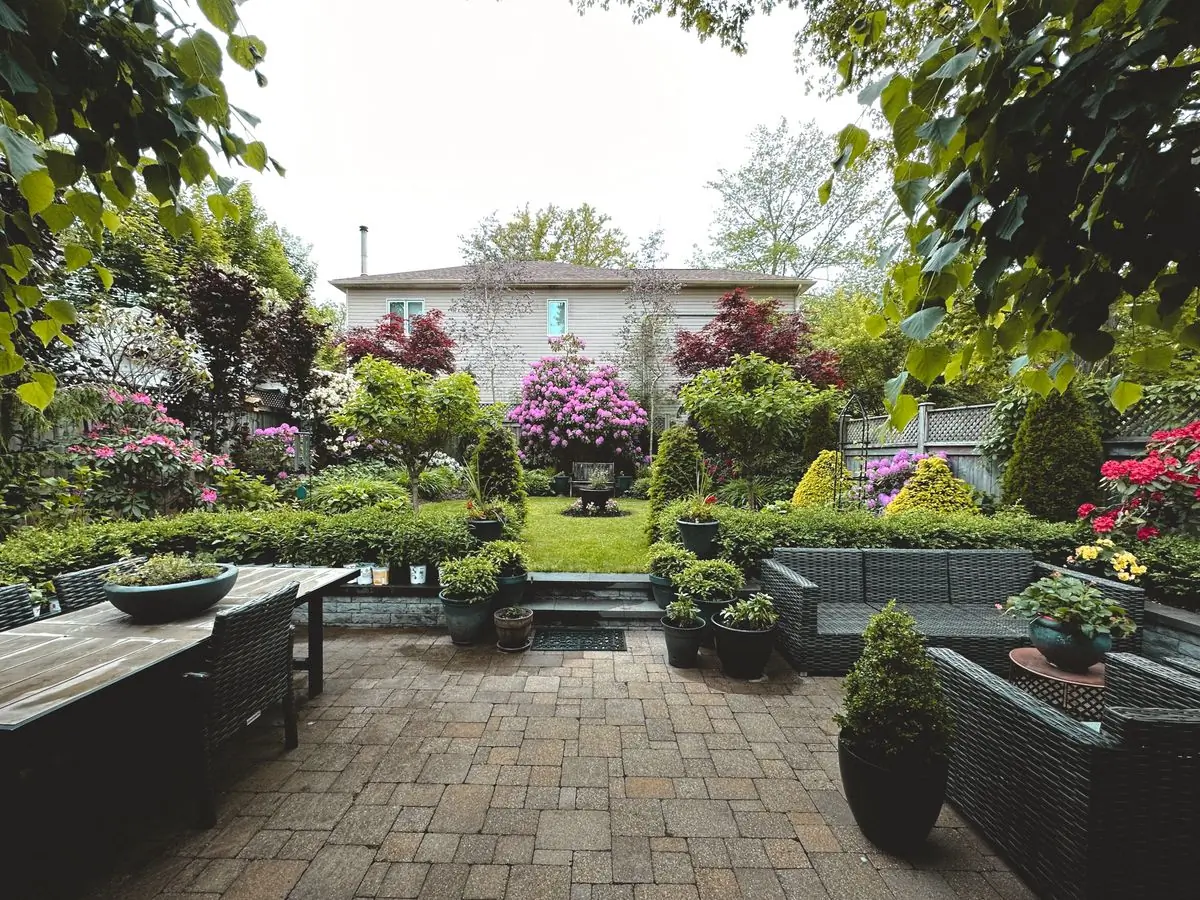 A planted patio with seating among flowering shrubs