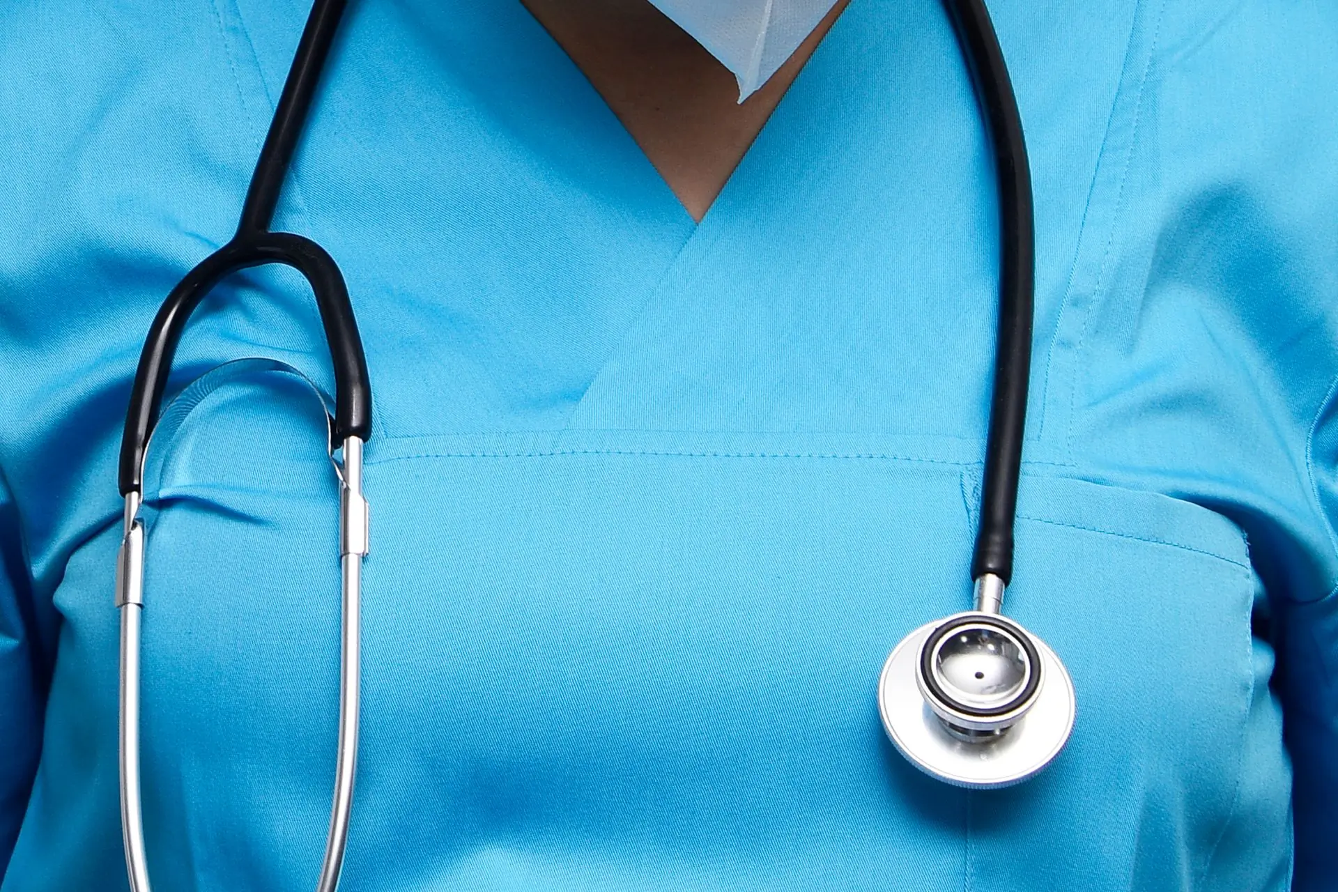 A clinician's stethoscope over scrubs, close up