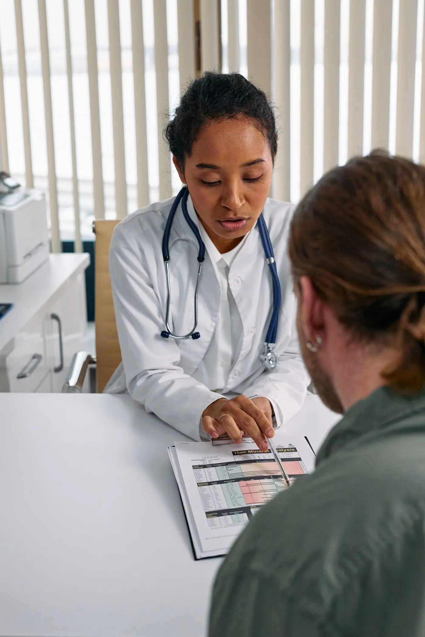 A doctor going through a patient's notes with him at the desk