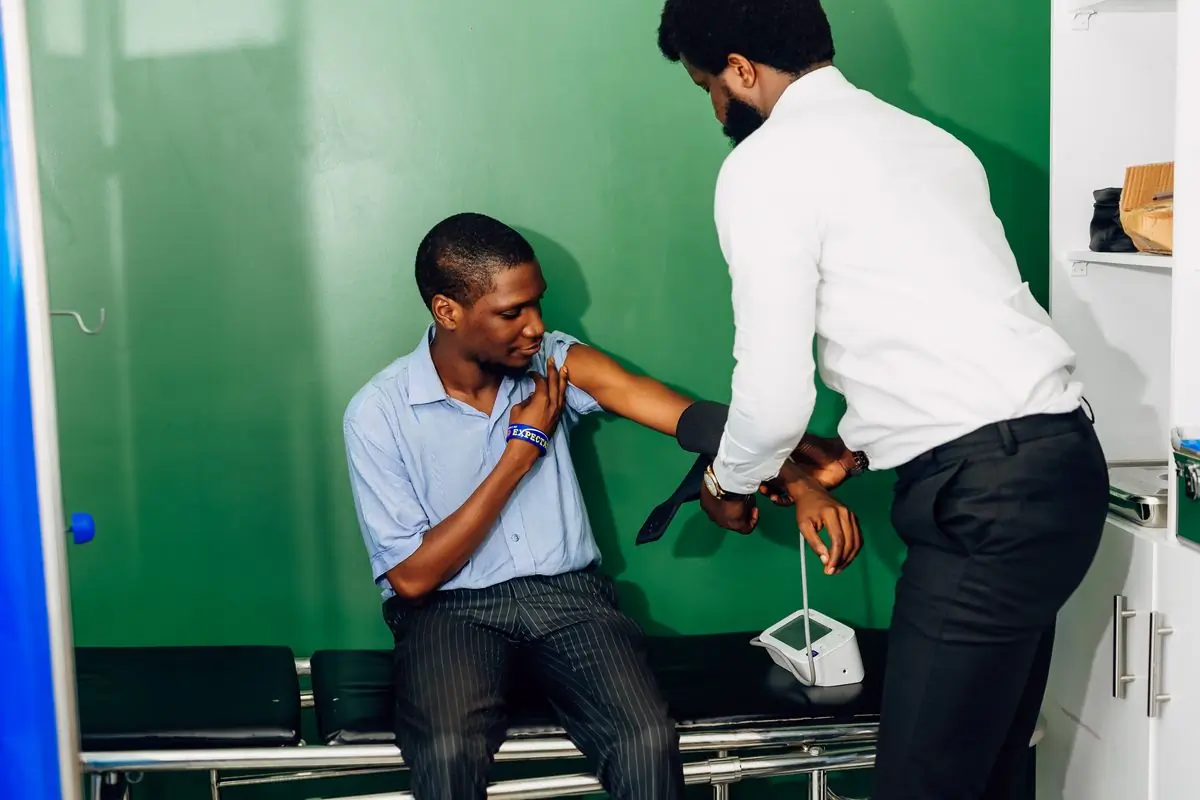 A clinician taking a patient's blood pressure at a clinic