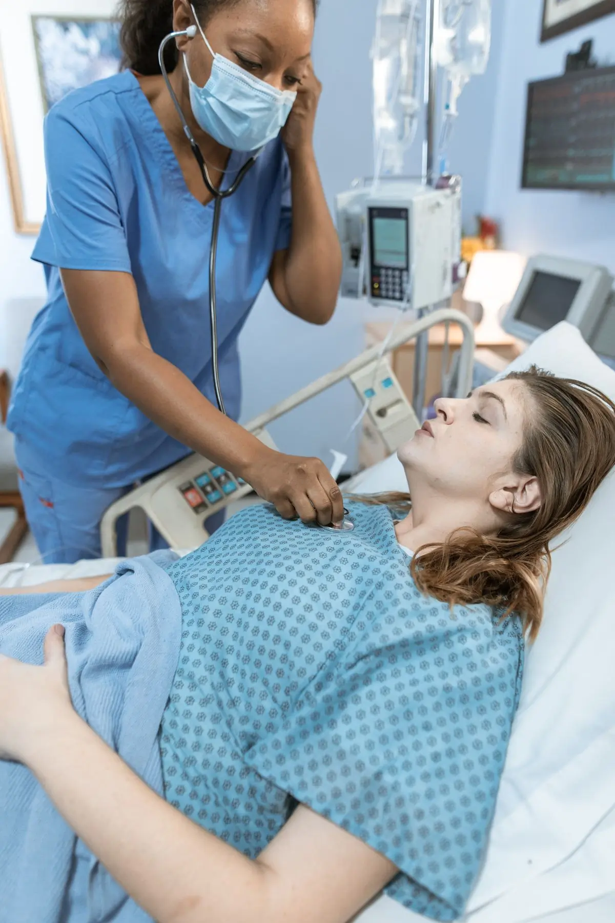 A nurse checking a patient's heartbeat at the bedside