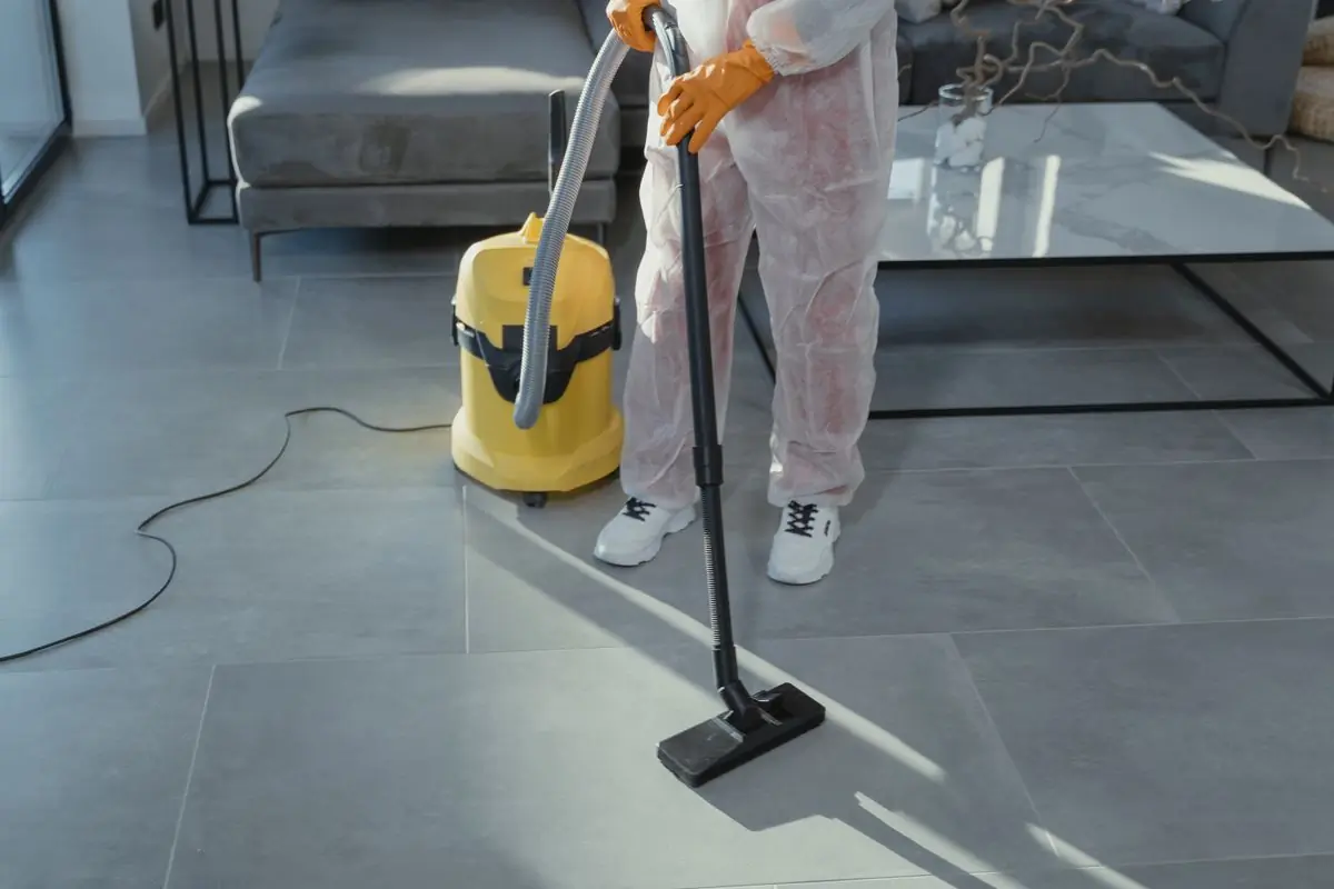 A Handy cleaner running an industrial vacuum across a living-room floor