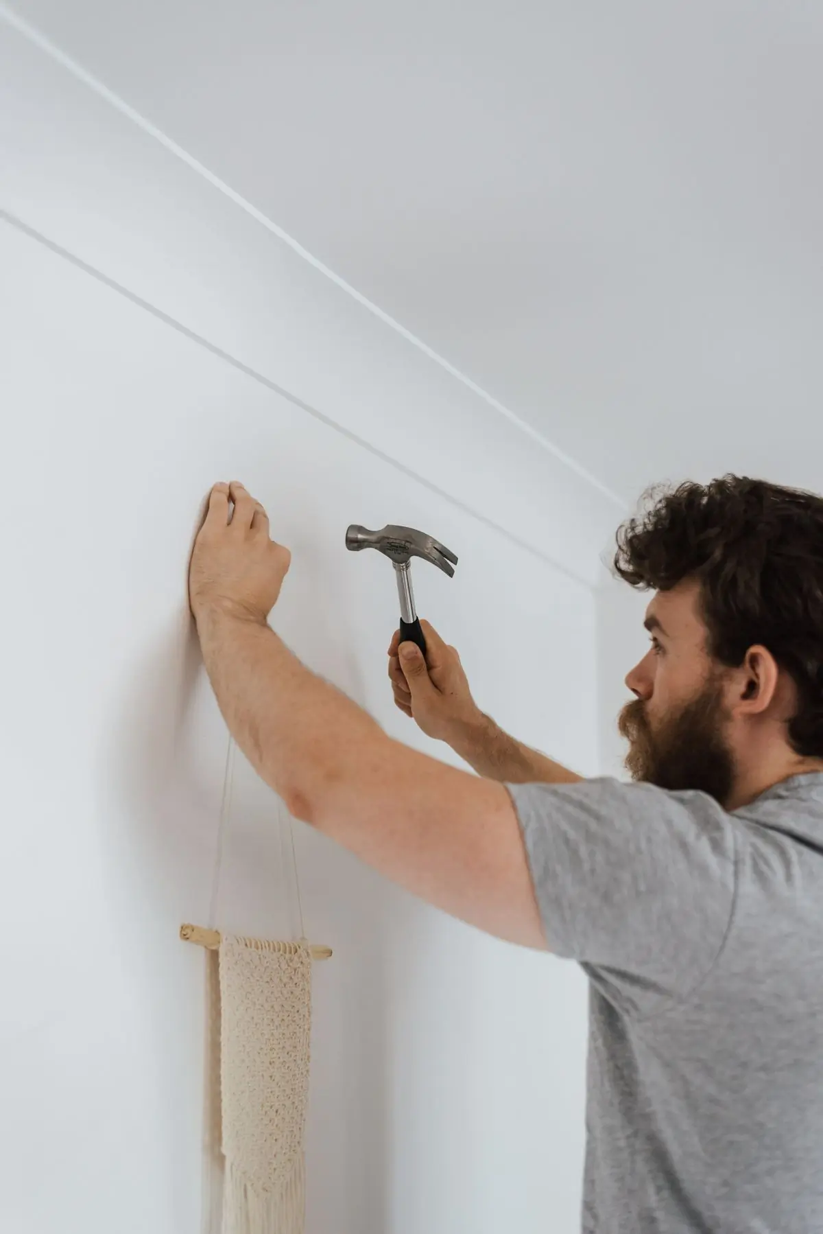 A Handy handyman fixing a fitting to a plastered wall