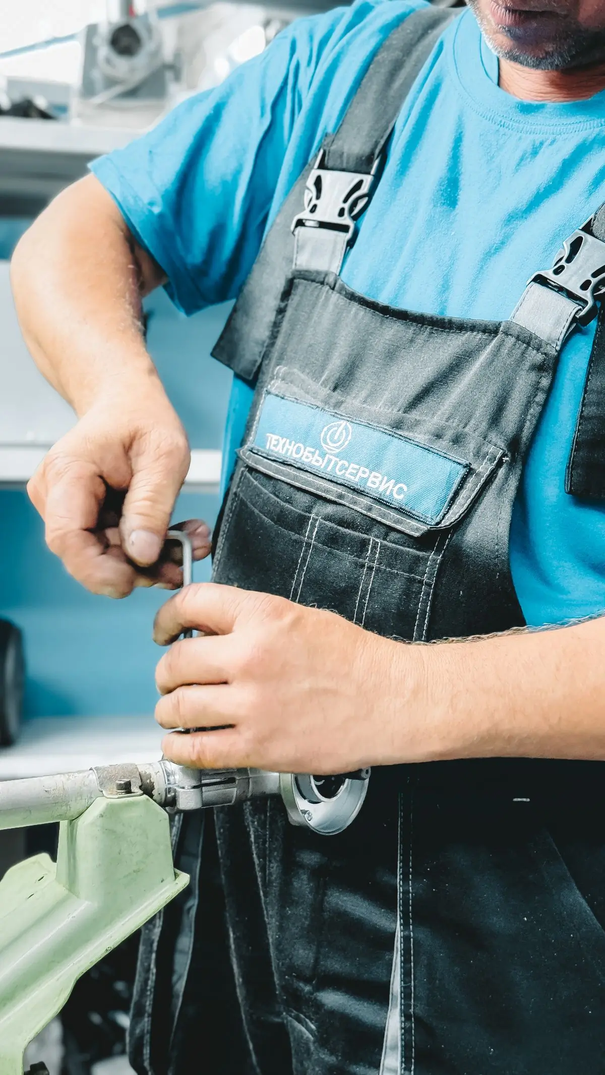 A Handy plumber tightening a pipe joint with a wrench