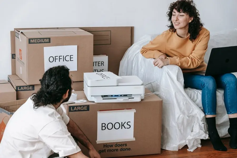 A couple sitting among labelled cartons planning a move