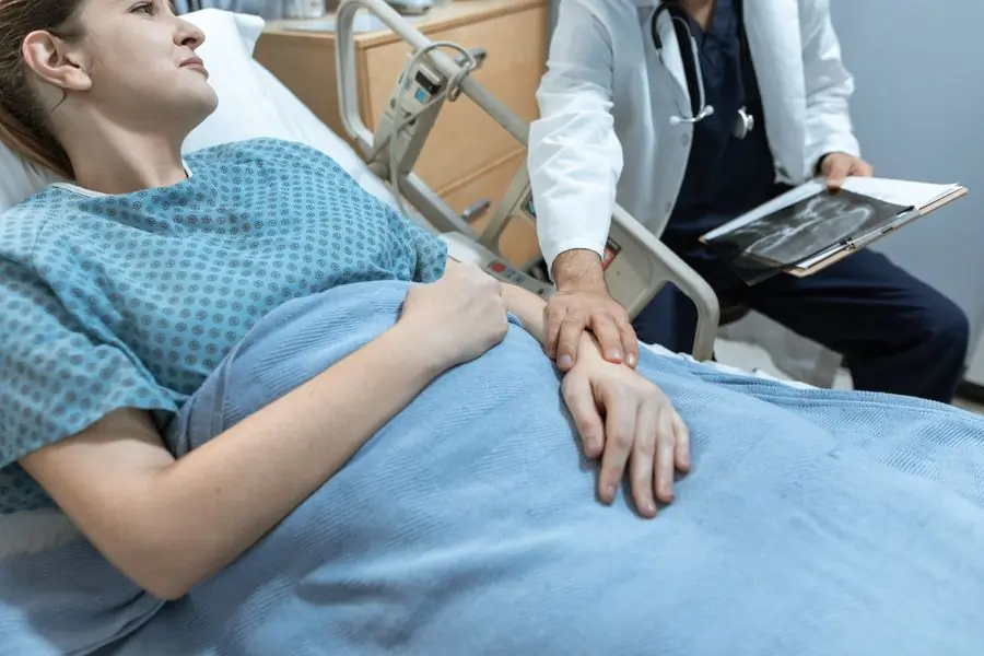 A clinician sitting with a patient at their bedside
