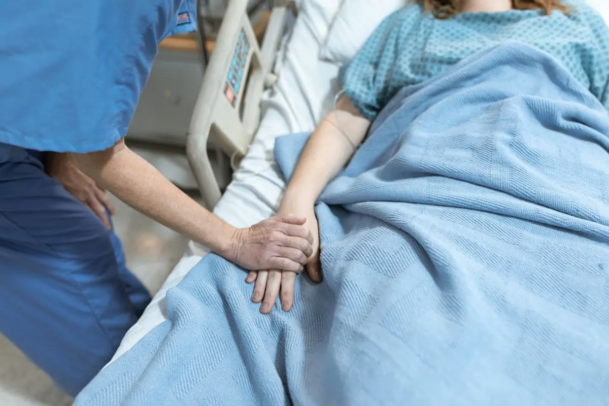 A nurse sitting with a patient on the ward
