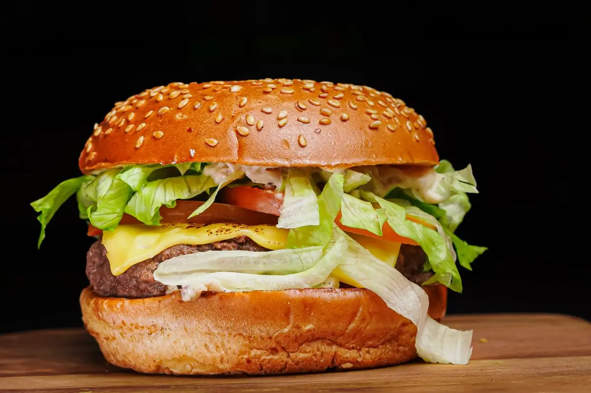 A classic cheeseburger with lettuce and tomato on a sesame bun