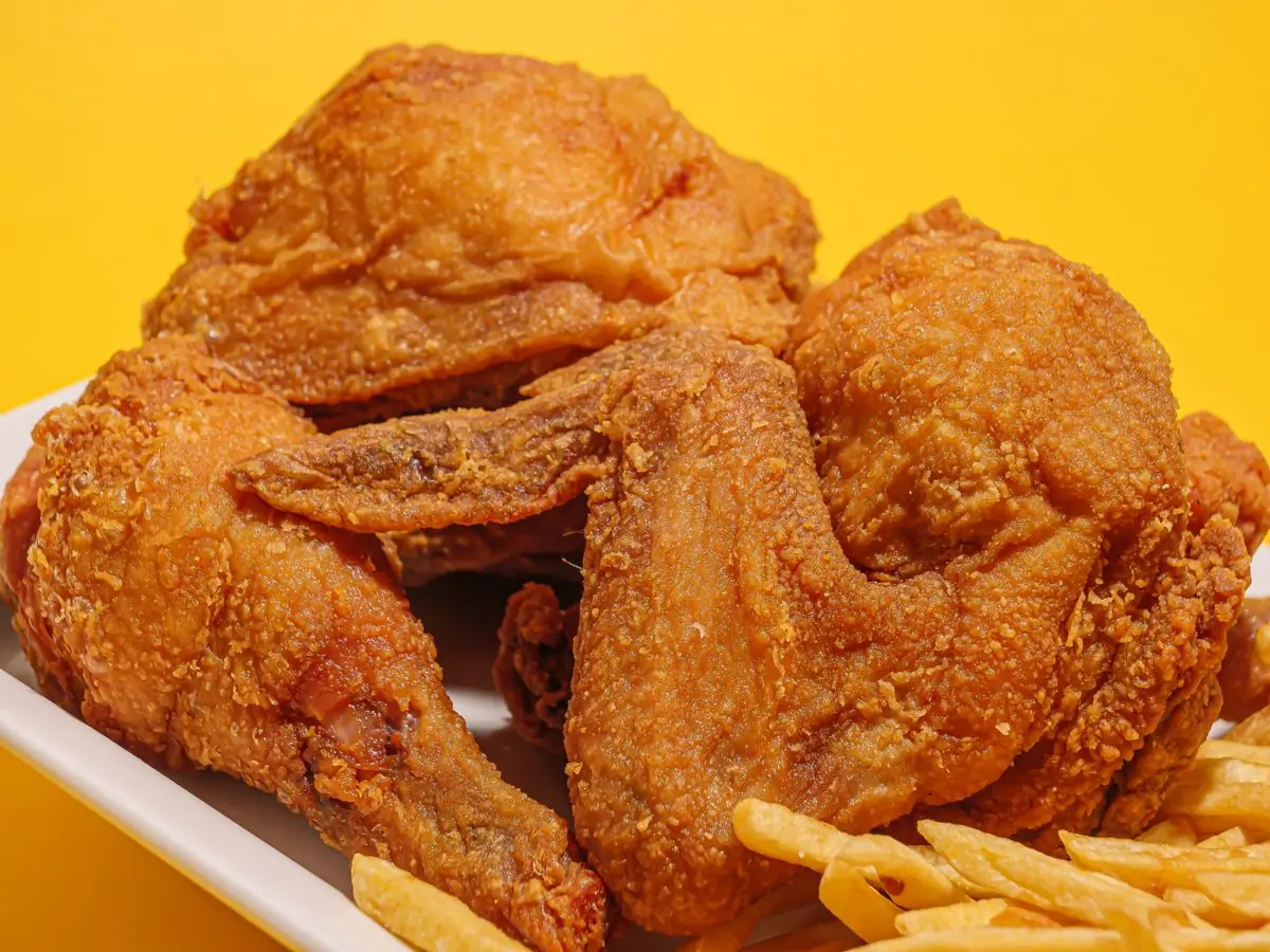Crispy fried chicken and fries on a bright yellow ground