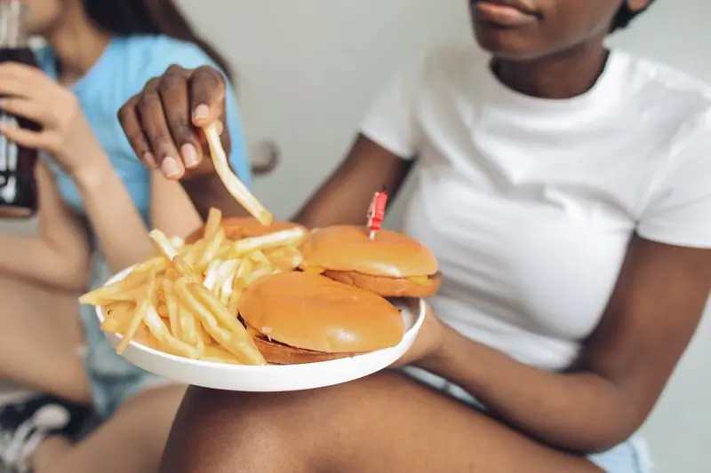 Two guests sharing a plate of burgers and fries