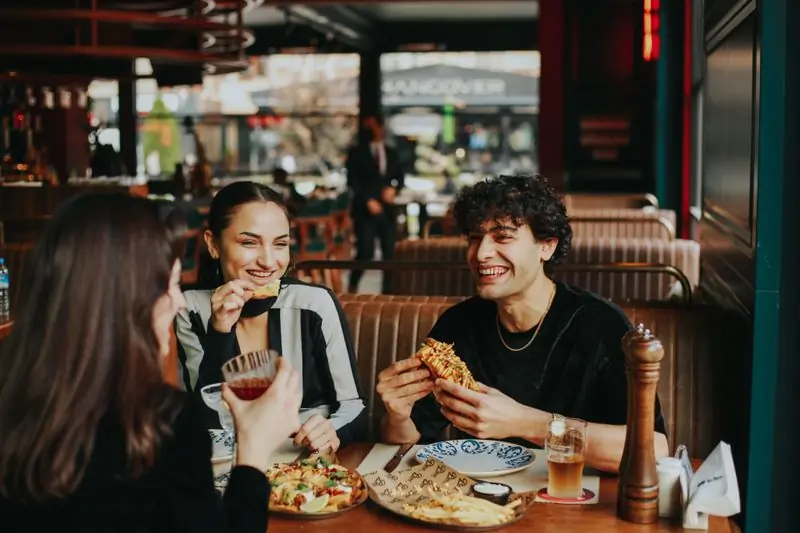 Two guests laughing over a shared plate
