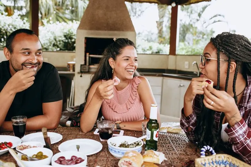Three friends at an outdoor table mid-meal