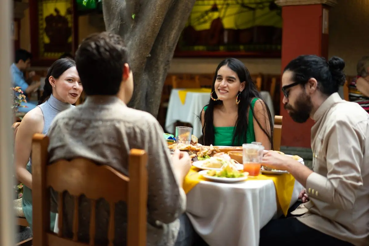 A long table of guests eating together outdoors