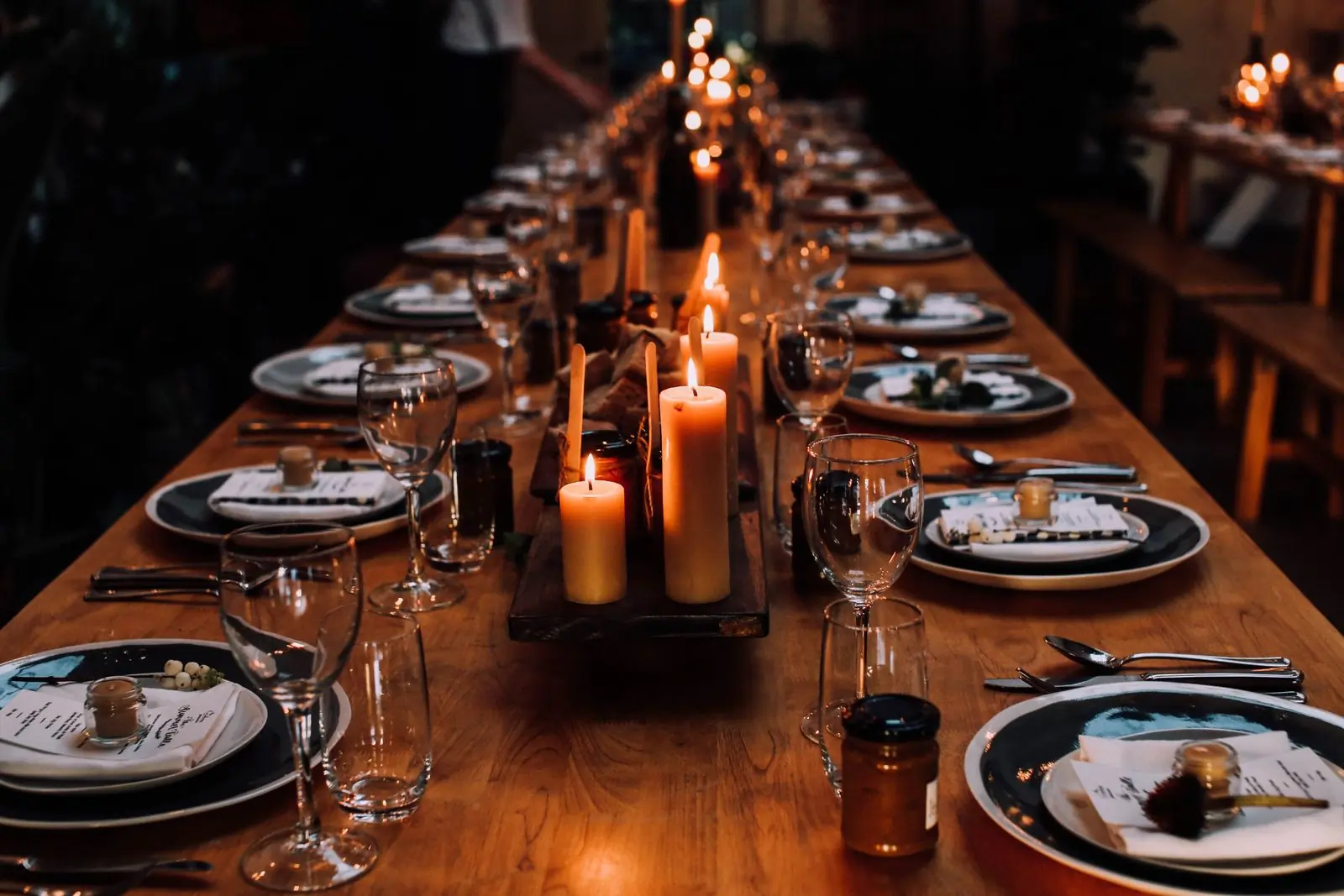 A long table laid with candles and plates for a private dinner