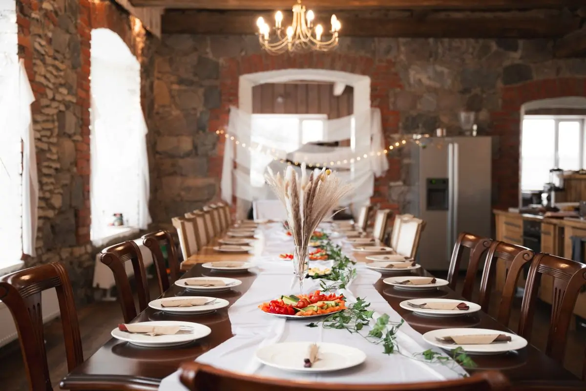 A long rustic table set with plates and silverware before guests arrive