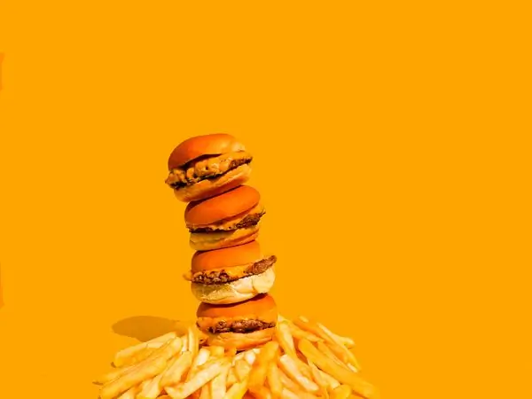 A stack of burgers over a bed of fries