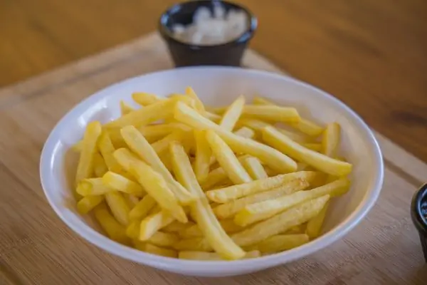 A white bowl of golden french fries
