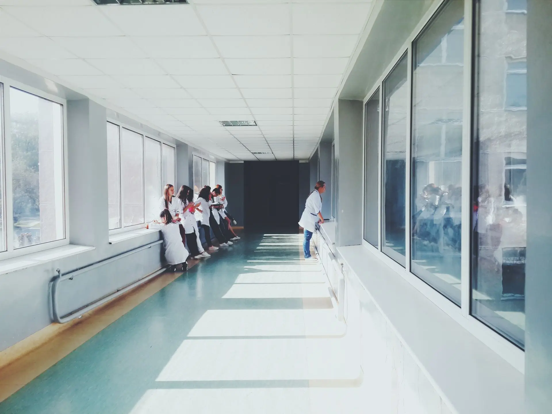 A sunlit corridor at Hope with clinicians along the window wall