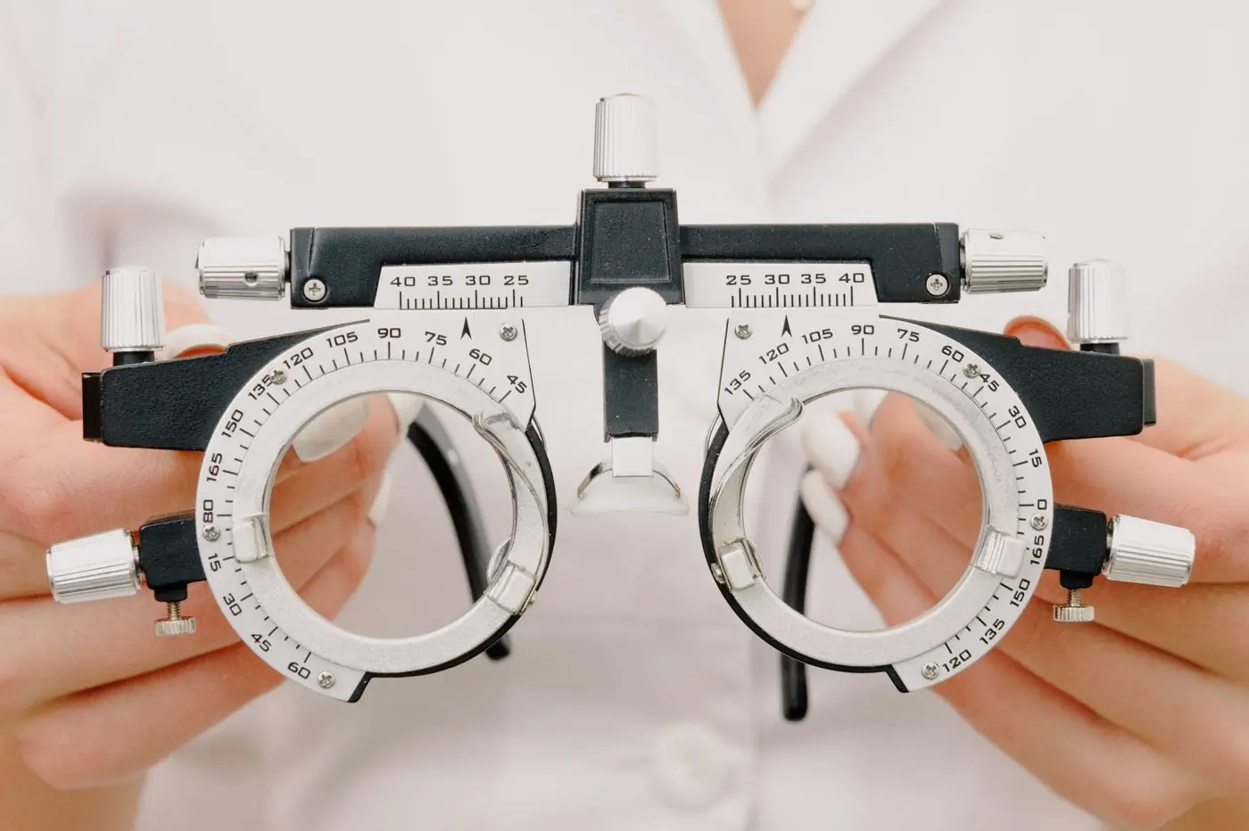 Hands holding a trial frame used in an eye test