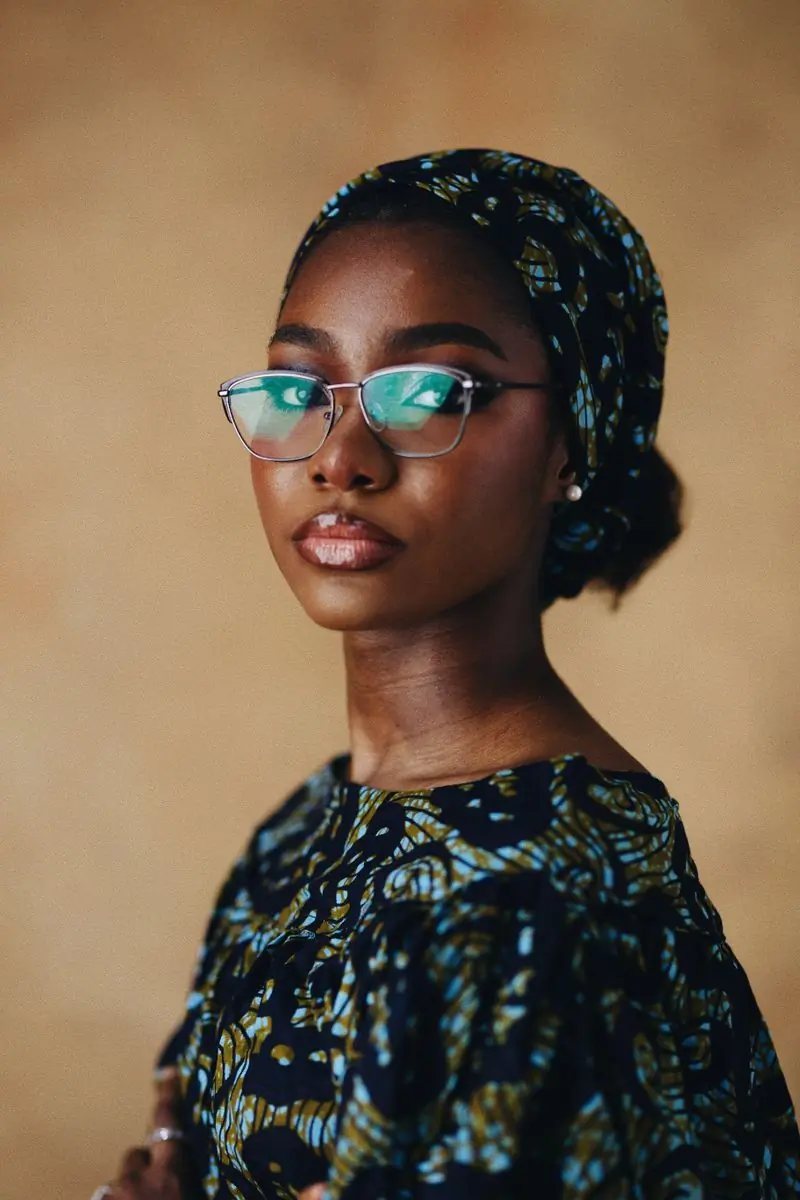 A woman in patterned metal frames looking to camera