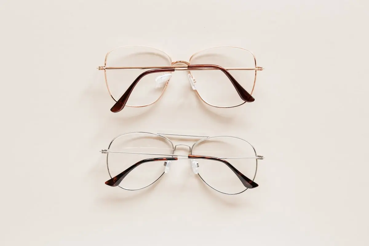 Two pairs of thin metal frames laid flat on a white surface