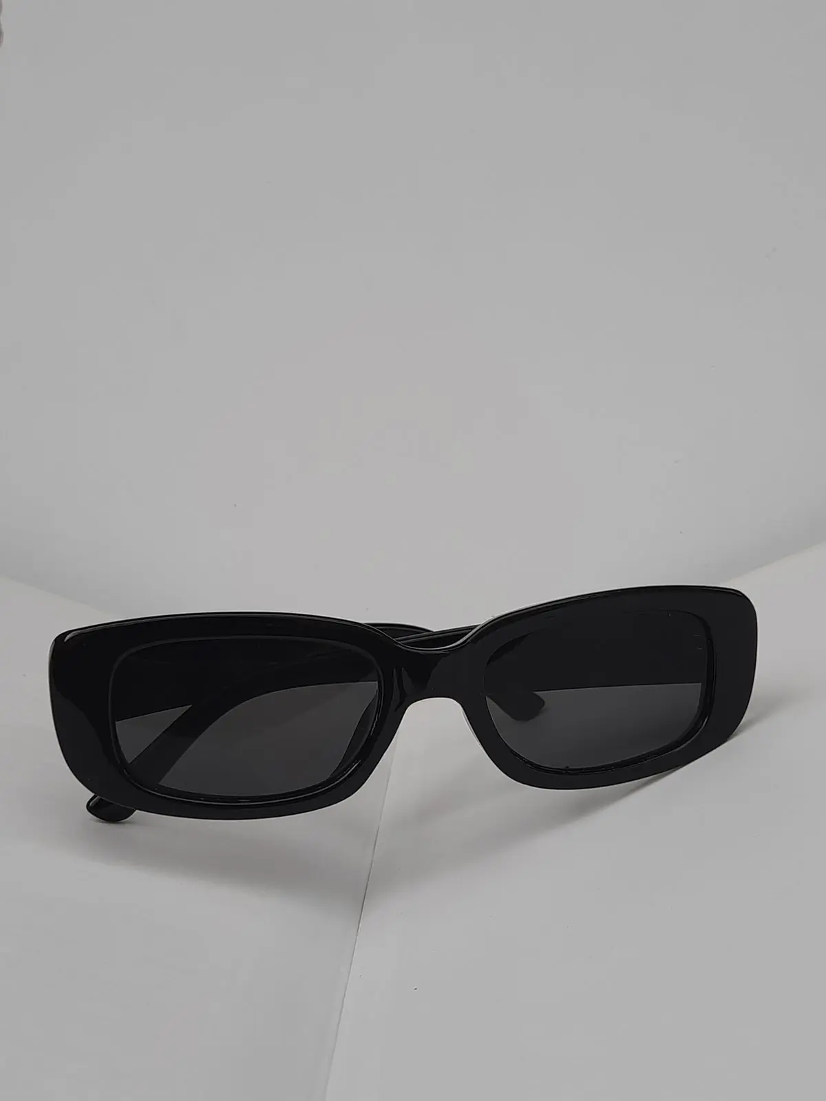 Black rectangular sunglasses photographed straight on