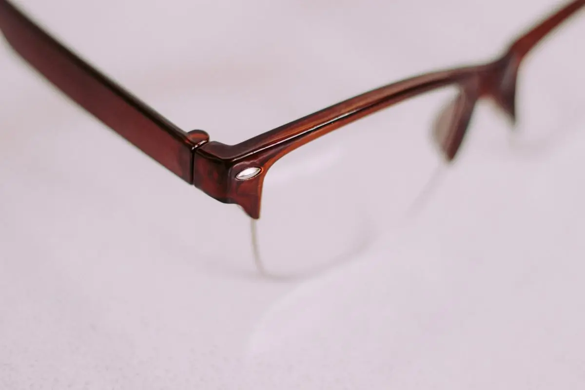 Close view of a brown half-rim frame corner on a pale lilac ground