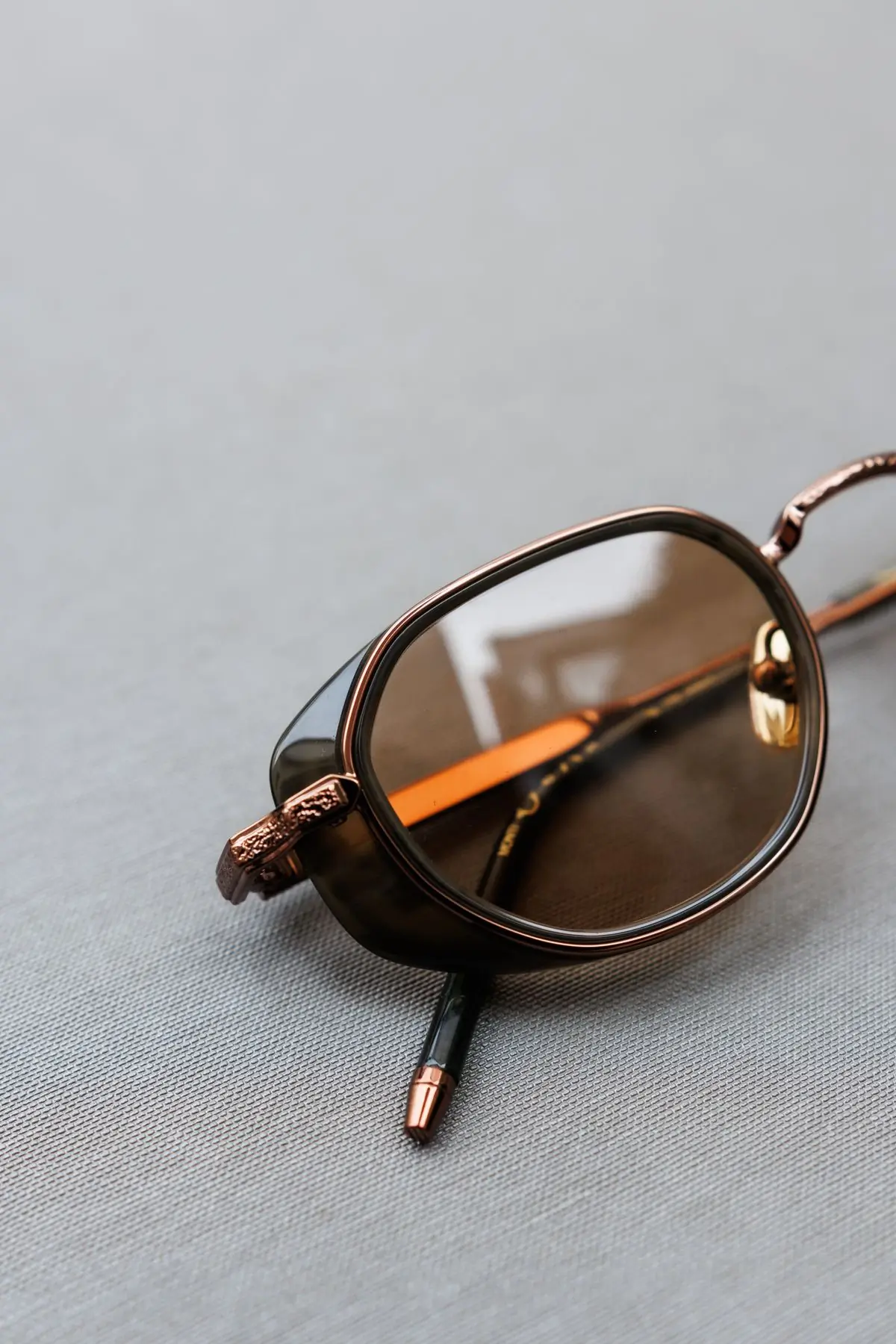 Brown optical frames resting on cool grey fabric