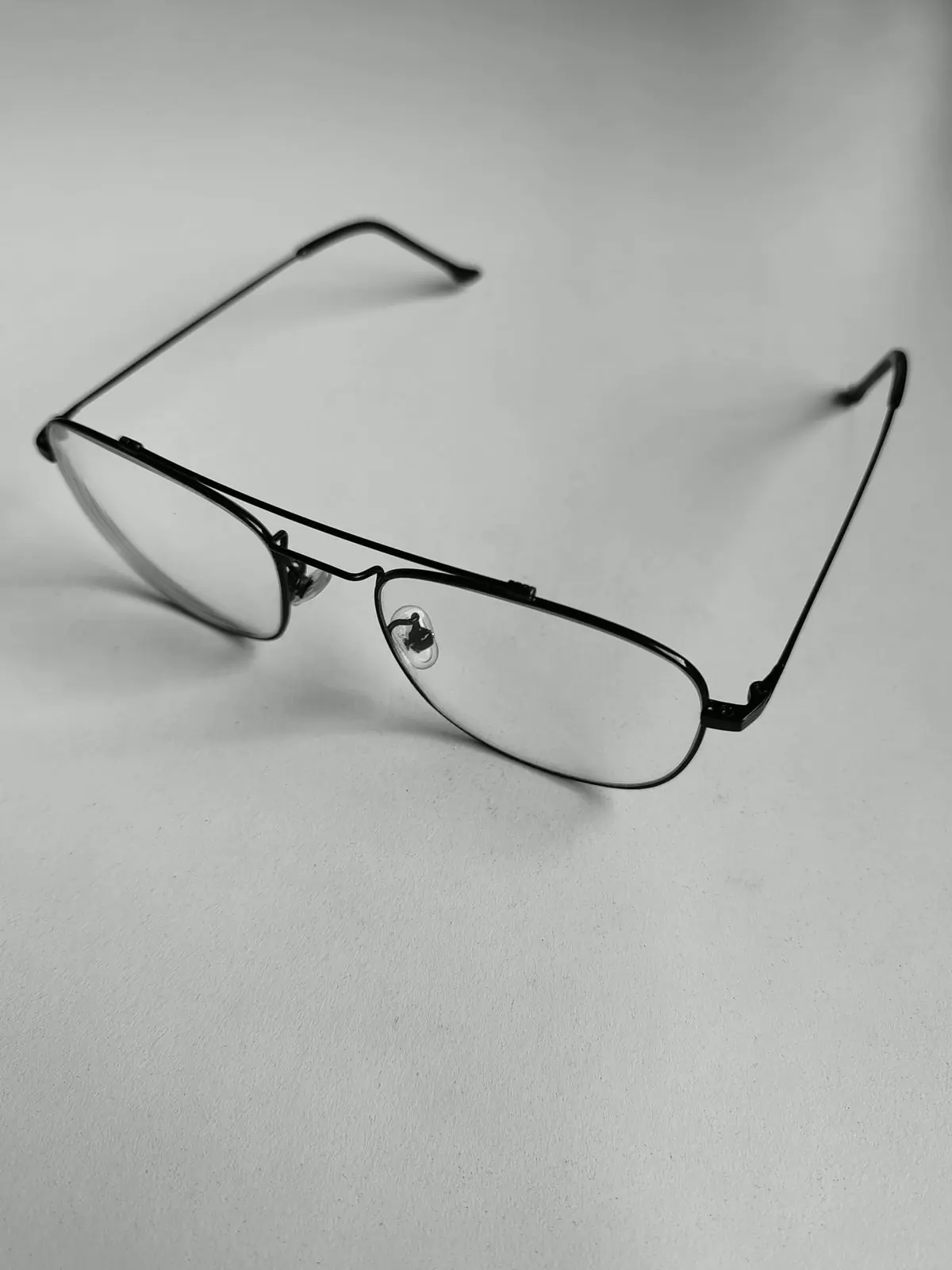 Black metal optical frames angled on a white surface