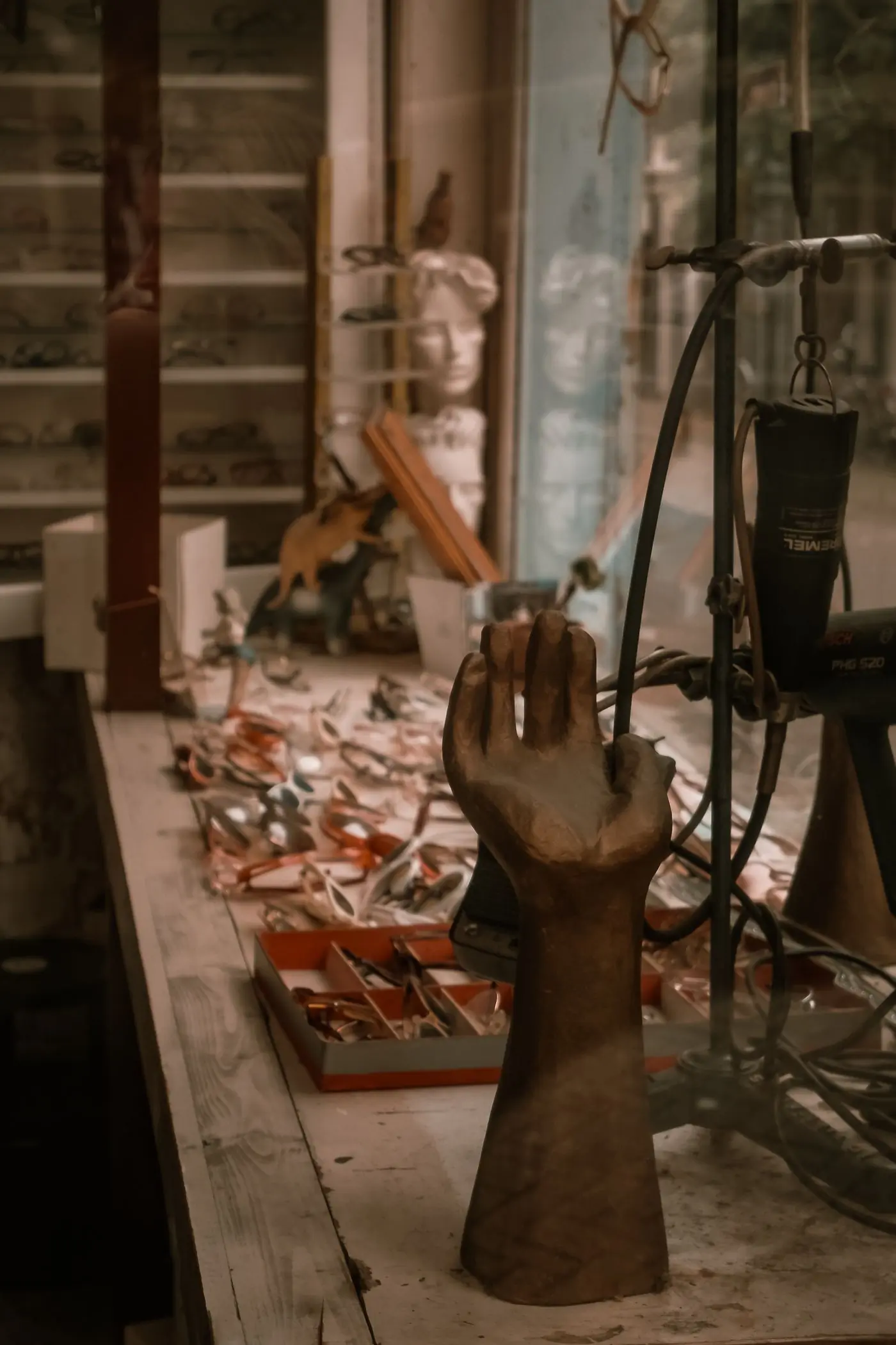 A vintage optician counter with frames and a wooden hand display