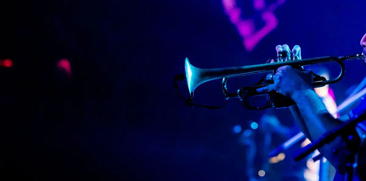 A trumpet catching blue stage light during a live set